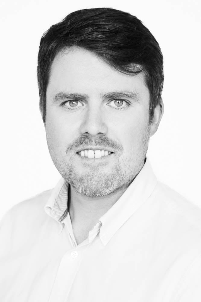 A black and white headshot of Oliver Lamb. 